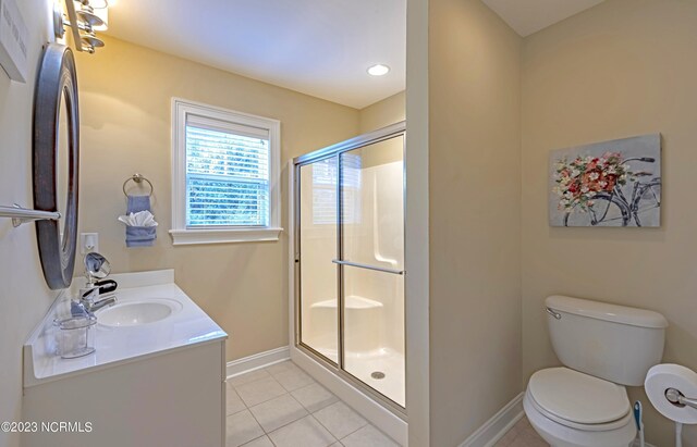 bathroom with vanity, tile patterned flooring, toilet, and walk in shower