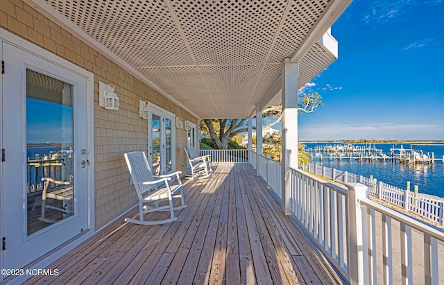 wooden terrace featuring a water view and french doors