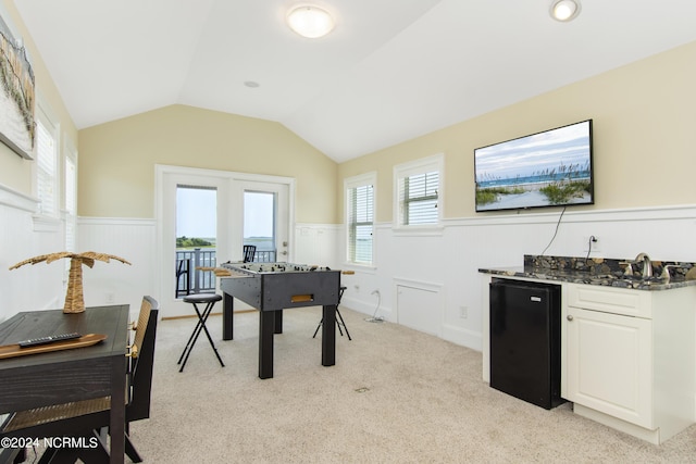 home office featuring lofted ceiling and light colored carpet