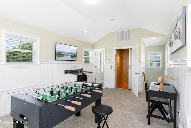 rec room featuring lofted ceiling and light carpet