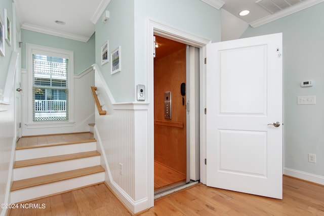 stairs with crown molding and light wood-type flooring