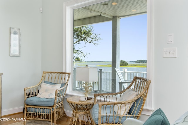 sitting room featuring hardwood / wood-style flooring and a water view