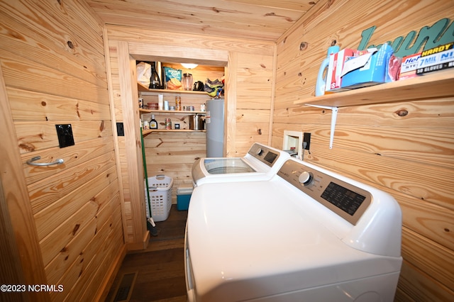 clothes washing area with washer hookup, water heater, wooden walls, washer and clothes dryer, and wooden ceiling