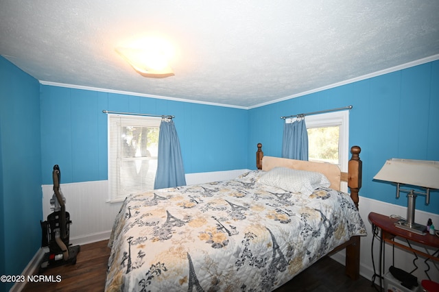 bedroom featuring dark hardwood / wood-style floors, ornamental molding, and a textured ceiling