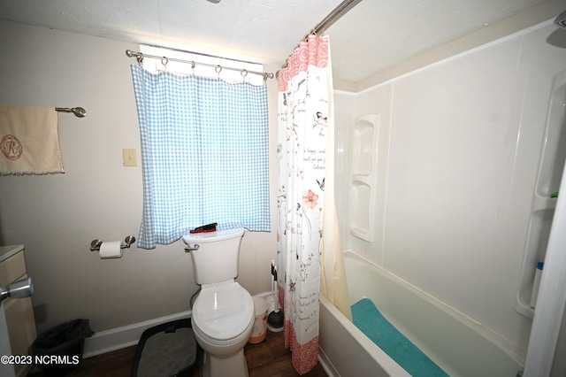 bathroom with hardwood / wood-style flooring, shower / bath combination with curtain, and toilet