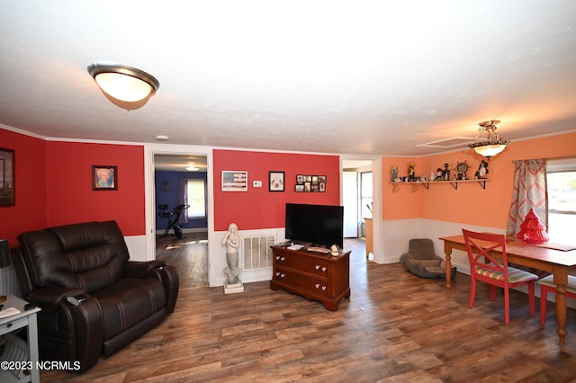 living room featuring a wealth of natural light, dark wood-type flooring, and ornamental molding