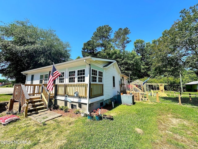 exterior space featuring a wooden deck and a front yard