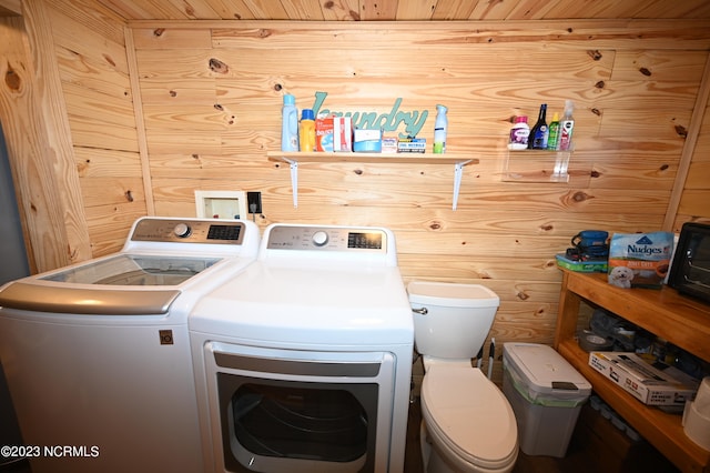 laundry area featuring wooden walls, washer hookup, wood ceiling, and washing machine and dryer