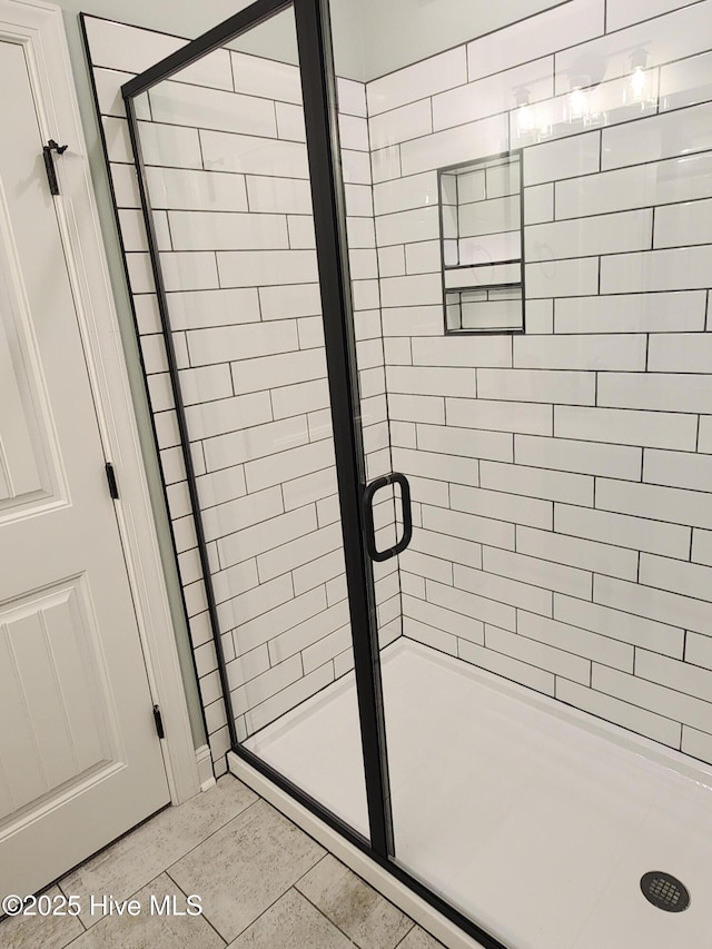 bathroom featuring tile patterned floors and a shower with shower door