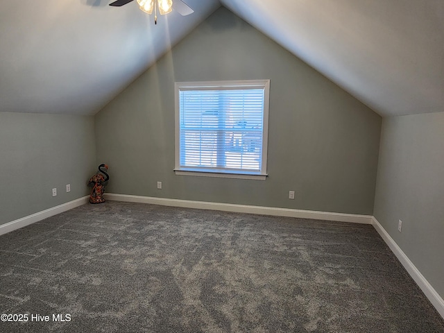 additional living space featuring ceiling fan, lofted ceiling, and dark colored carpet