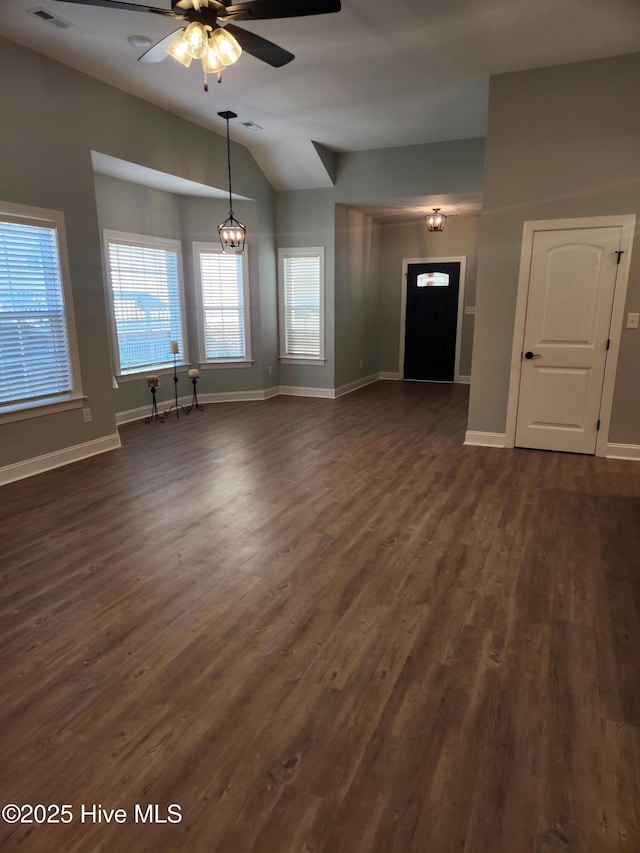 unfurnished living room featuring ceiling fan with notable chandelier, dark hardwood / wood-style floors, and lofted ceiling