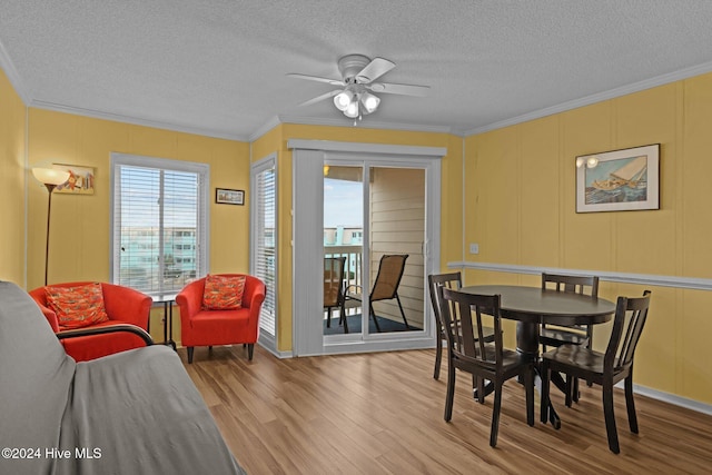 dining area featuring a textured ceiling, light hardwood / wood-style floors, ceiling fan, and crown molding