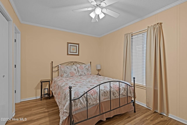 bedroom with hardwood / wood-style floors, ceiling fan, crown molding, and a textured ceiling