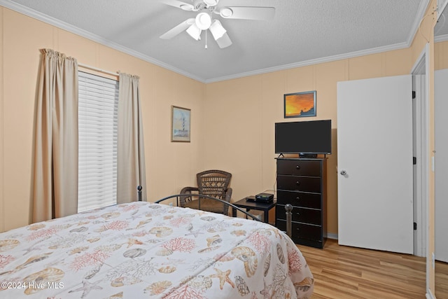 bedroom with a textured ceiling, light hardwood / wood-style flooring, ceiling fan, and ornamental molding