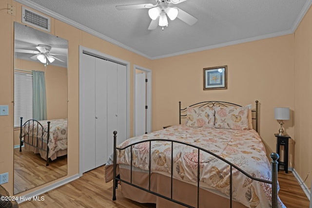 bedroom featuring hardwood / wood-style floors, ceiling fan, ornamental molding, a textured ceiling, and a closet