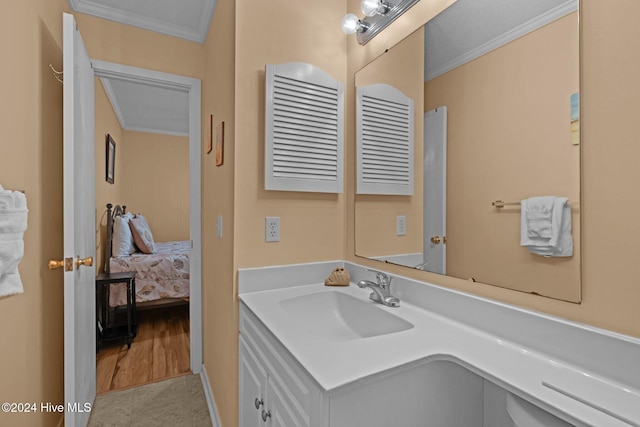 bathroom with crown molding, vanity, and hardwood / wood-style flooring