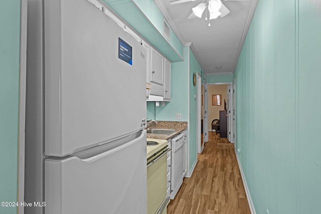 kitchen with light wood-type flooring, white appliances, crown molding, sink, and white cabinetry