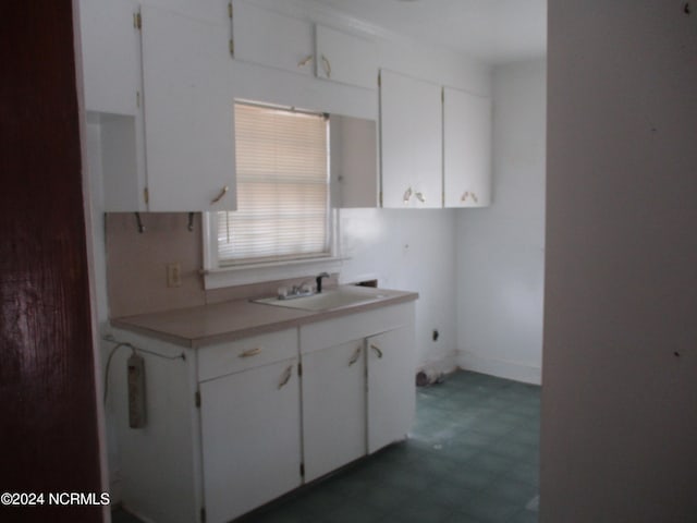 kitchen featuring sink and white cabinets