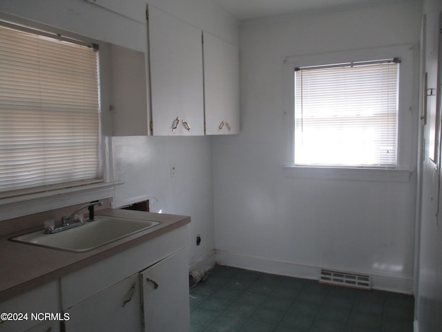 kitchen featuring white cabinetry and sink