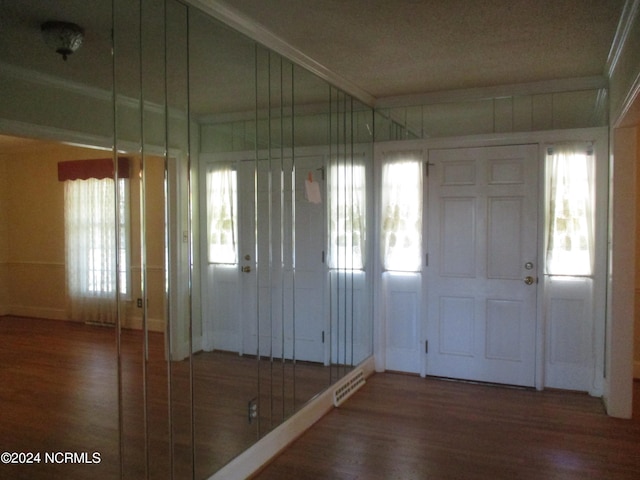 entrance foyer with dark hardwood / wood-style floors and crown molding