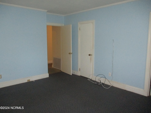 carpeted spare room featuring crown molding