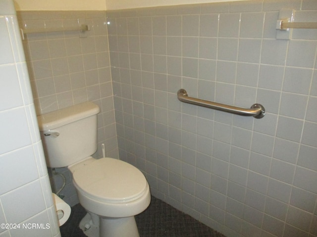 bathroom featuring toilet and tile walls