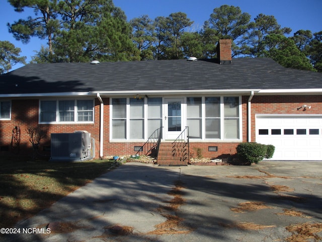 view of front of property with a garage and central AC unit