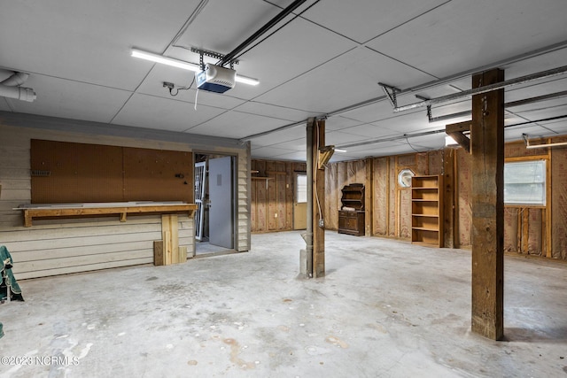 garage featuring a garage door opener and wood walls