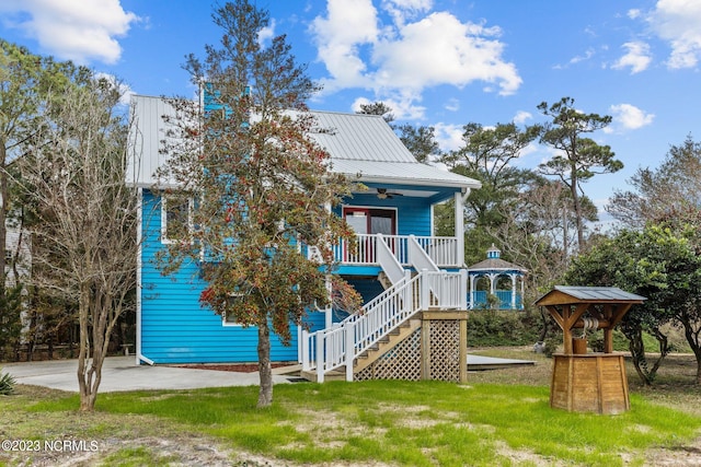 back of house with ceiling fan, a porch, and a yard