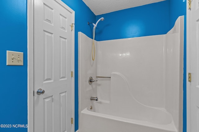 bathroom featuring bathing tub / shower combination and a textured ceiling