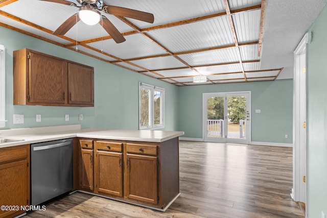 kitchen with kitchen peninsula, stainless steel dishwasher, ceiling fan, sink, and light hardwood / wood-style flooring