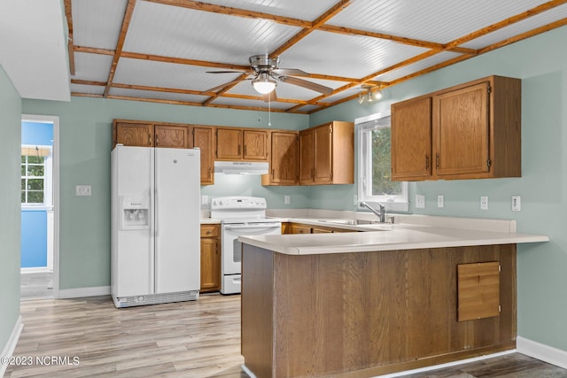 kitchen featuring kitchen peninsula, white appliances, light hardwood / wood-style flooring, and sink