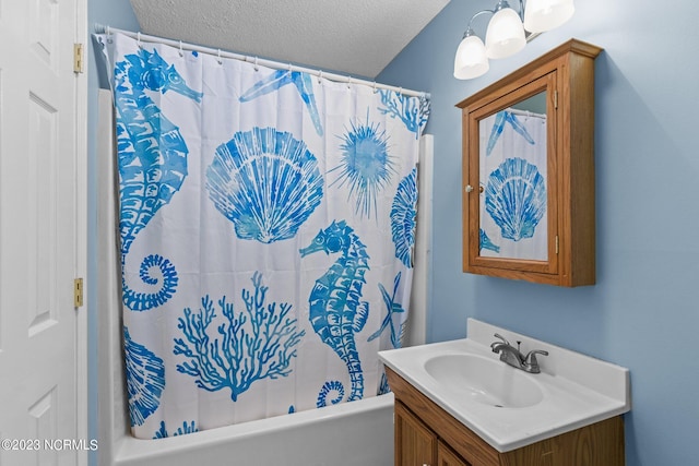 bathroom featuring shower / bathtub combination with curtain, vanity, and a textured ceiling