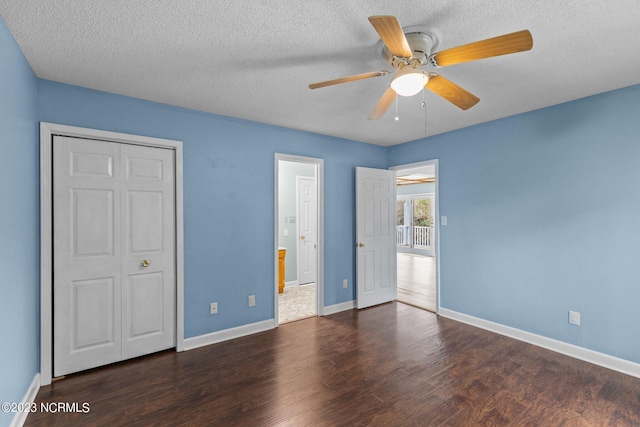 unfurnished bedroom with a textured ceiling, dark hardwood / wood-style flooring, and ceiling fan