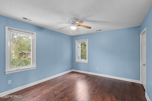 spare room featuring ceiling fan, dark hardwood / wood-style flooring, and a textured ceiling