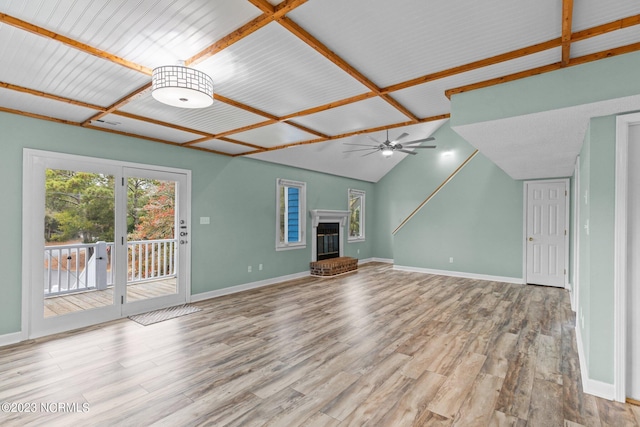 unfurnished living room featuring ceiling fan, lofted ceiling, a fireplace, and light hardwood / wood-style flooring