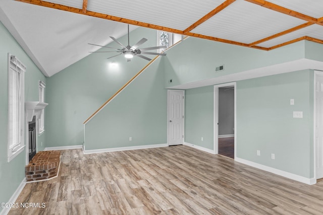 unfurnished living room featuring ceiling fan, a fireplace, high vaulted ceiling, and light hardwood / wood-style floors