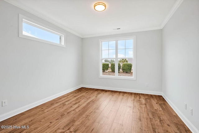 empty room featuring hardwood / wood-style flooring, plenty of natural light, and ornamental molding