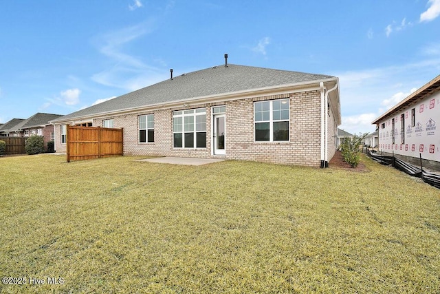 rear view of property with a patio and a yard