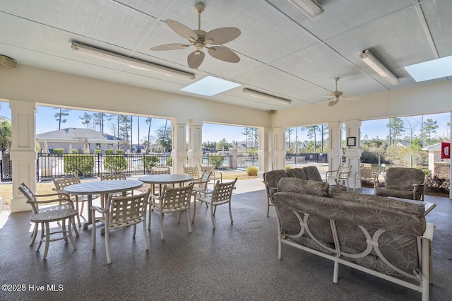 sunroom with a healthy amount of sunlight, ceiling fan, and a skylight