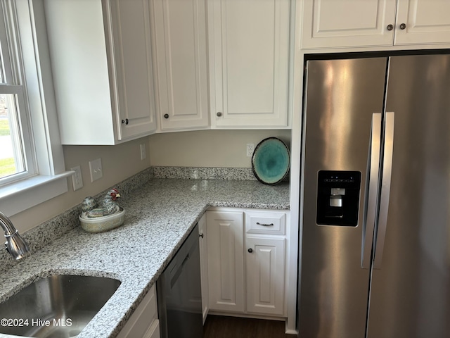 kitchen with light stone countertops, white cabinetry, sink, and appliances with stainless steel finishes