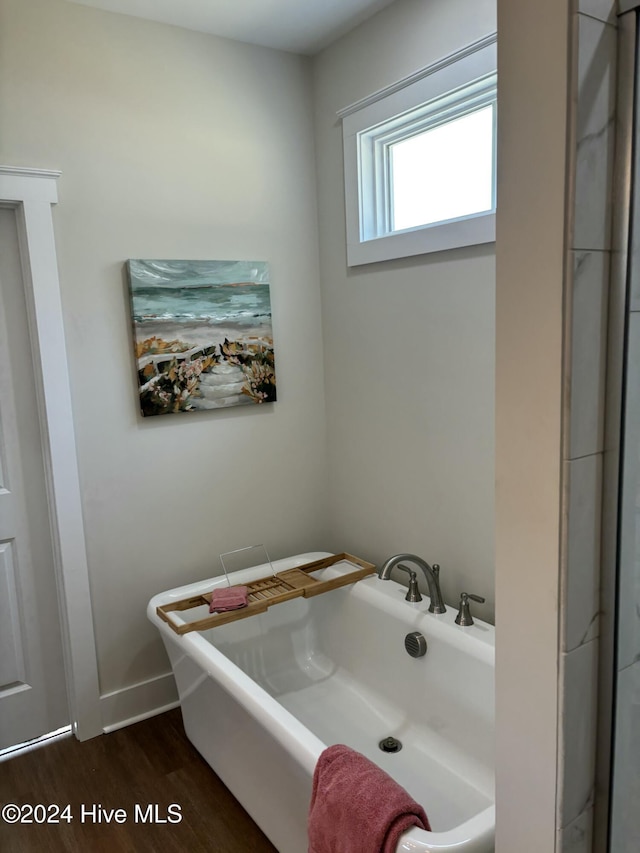 bathroom featuring hardwood / wood-style flooring and a tub