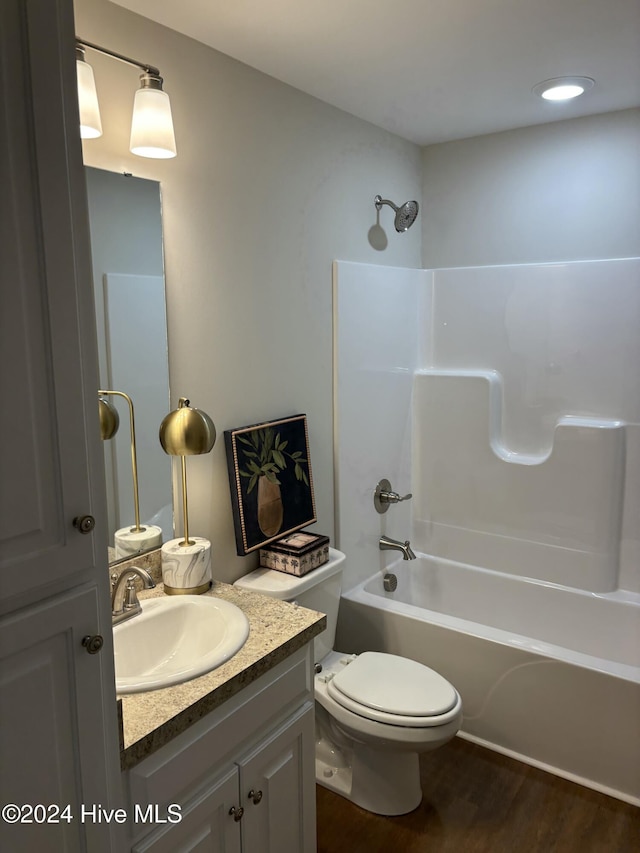 full bathroom with hardwood / wood-style flooring, vanity, toilet, and shower / washtub combination