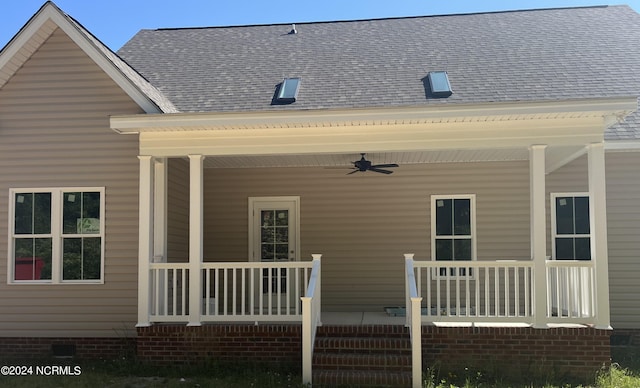 rear view of property featuring ceiling fan and a porch