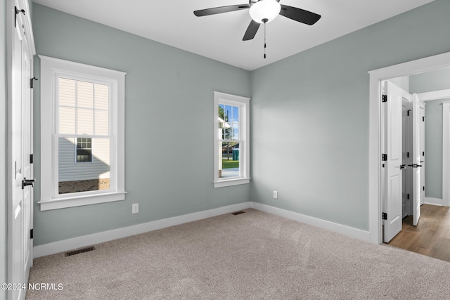 spare room featuring light hardwood / wood-style floors, ceiling fan, and a healthy amount of sunlight