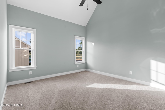 carpeted empty room featuring ceiling fan and high vaulted ceiling