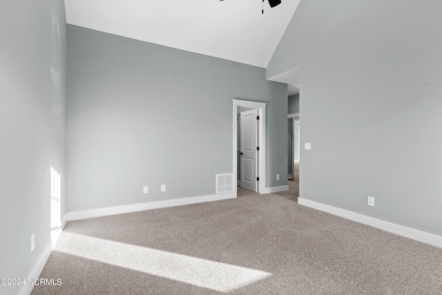 carpeted empty room with high vaulted ceiling and ceiling fan