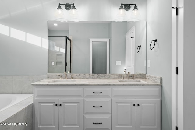 bathroom featuring double sink vanity and a relaxing tiled bath