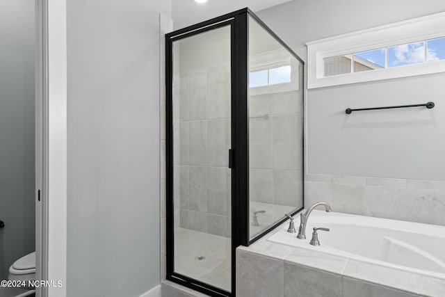 bathroom with a healthy amount of sunlight, toilet, and separate shower and tub