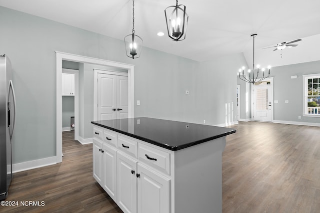 kitchen featuring a kitchen island, ceiling fan with notable chandelier, dark wood-type flooring, white cabinetry, and hanging light fixtures